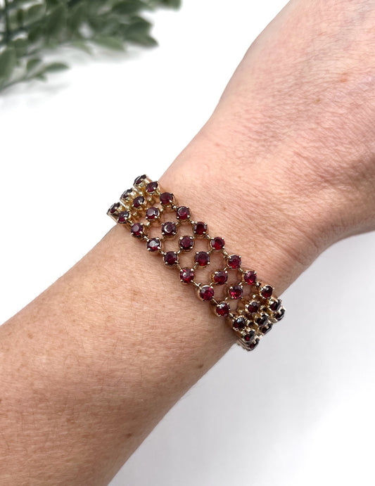 A triple row garnet bracelet in rose gold, modelled on a wrist