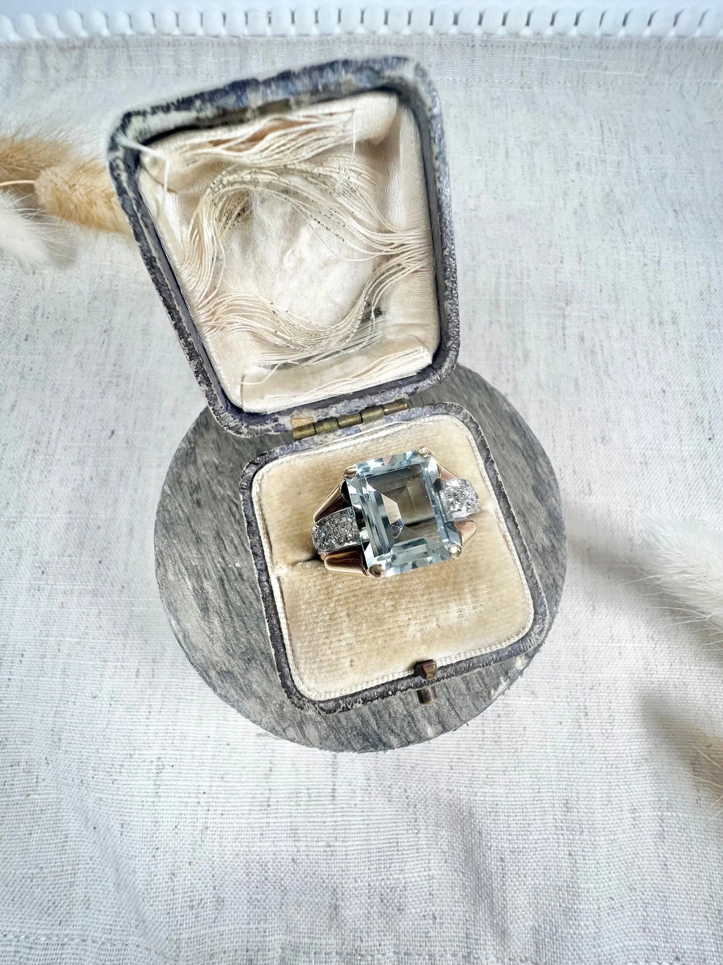 An aquamarine and diamond cocktail ring in gold, in an antique ring box