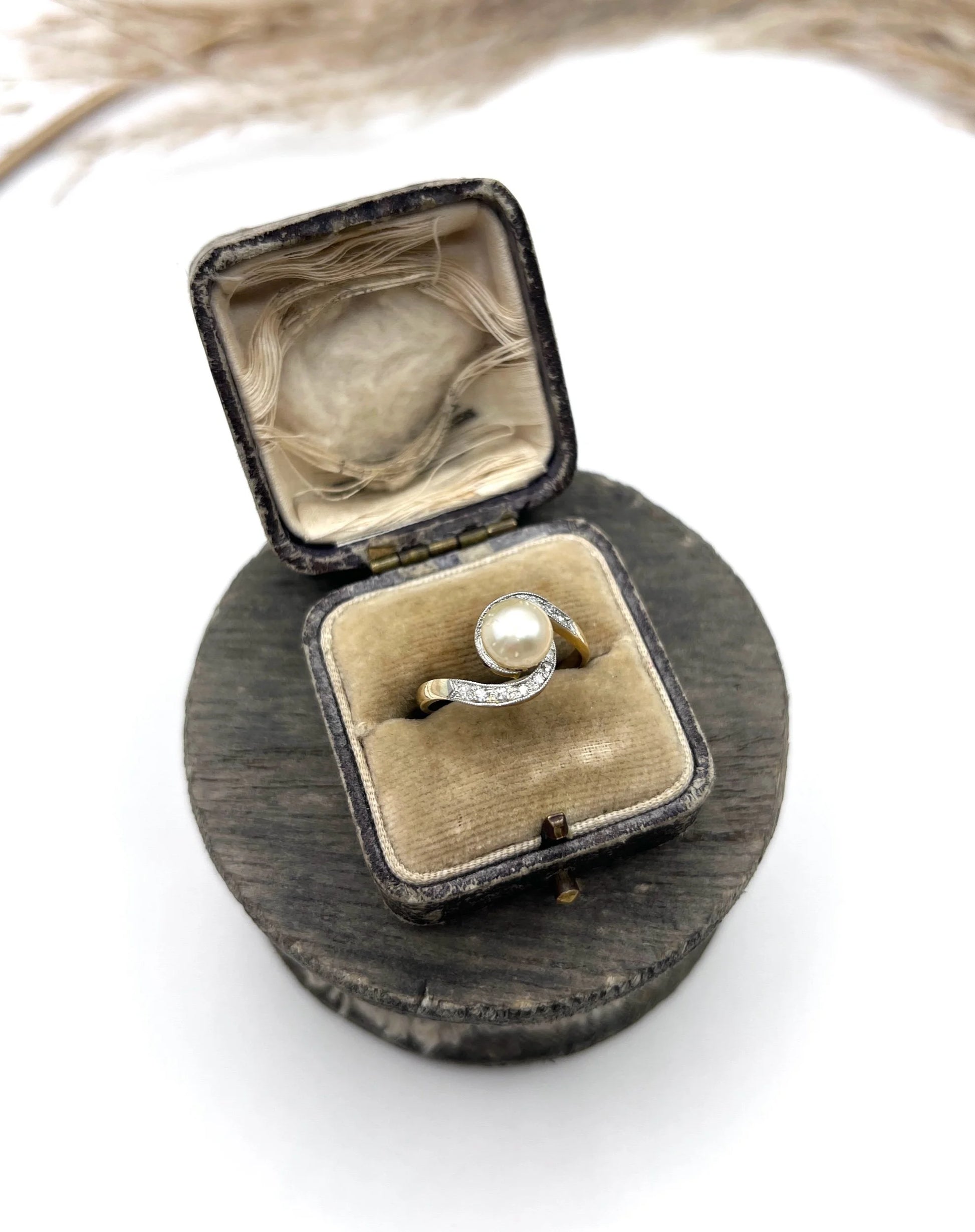 A pearl and diamond crossover swirl ring in yellow and white gold, in an antique ring box