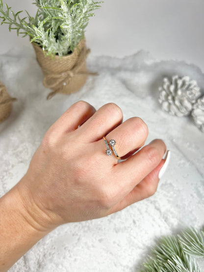 A two stone diamond crossover ring in yellow and white gold, modelled on a hand