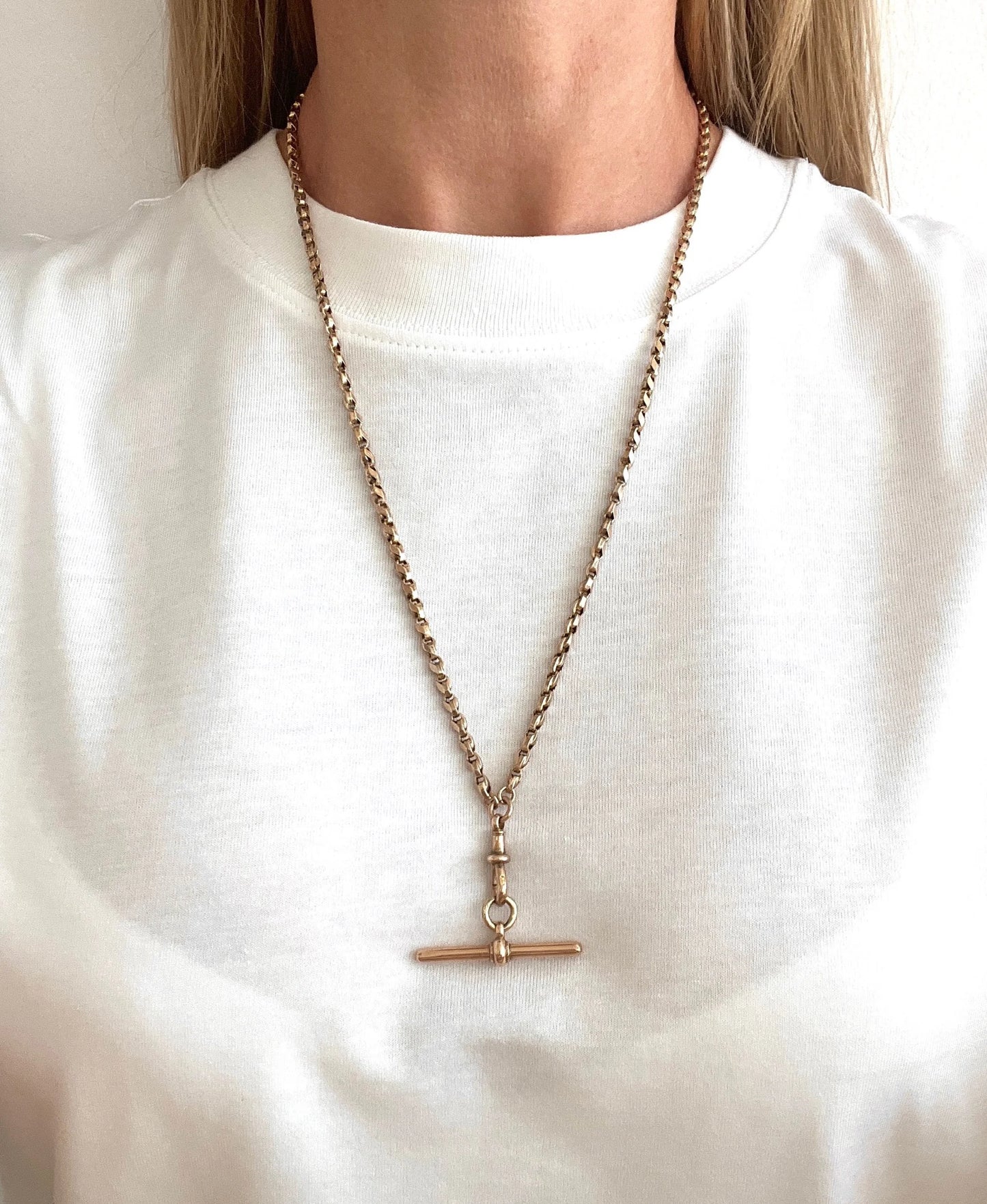 A rose gold tulip link chain necklace with a dog clip clasp and T-bar, modelled