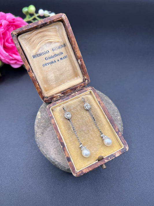 A pair of long drop platinum earrings with pearls and diamonds, in an antique box