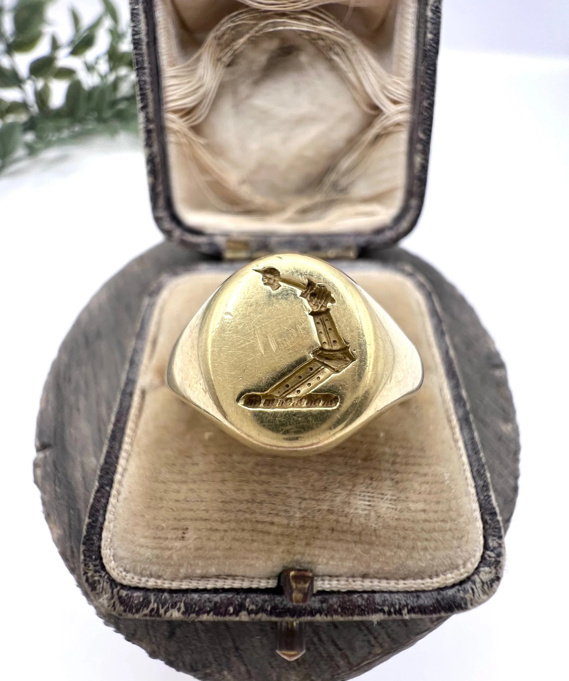 A yellow gold oval signet ring with a seal engraved heraldic crest, in an antique ring box