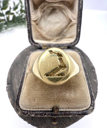 A yellow gold oval signet ring with a seal engraved heraldic crest, in an antique ring box