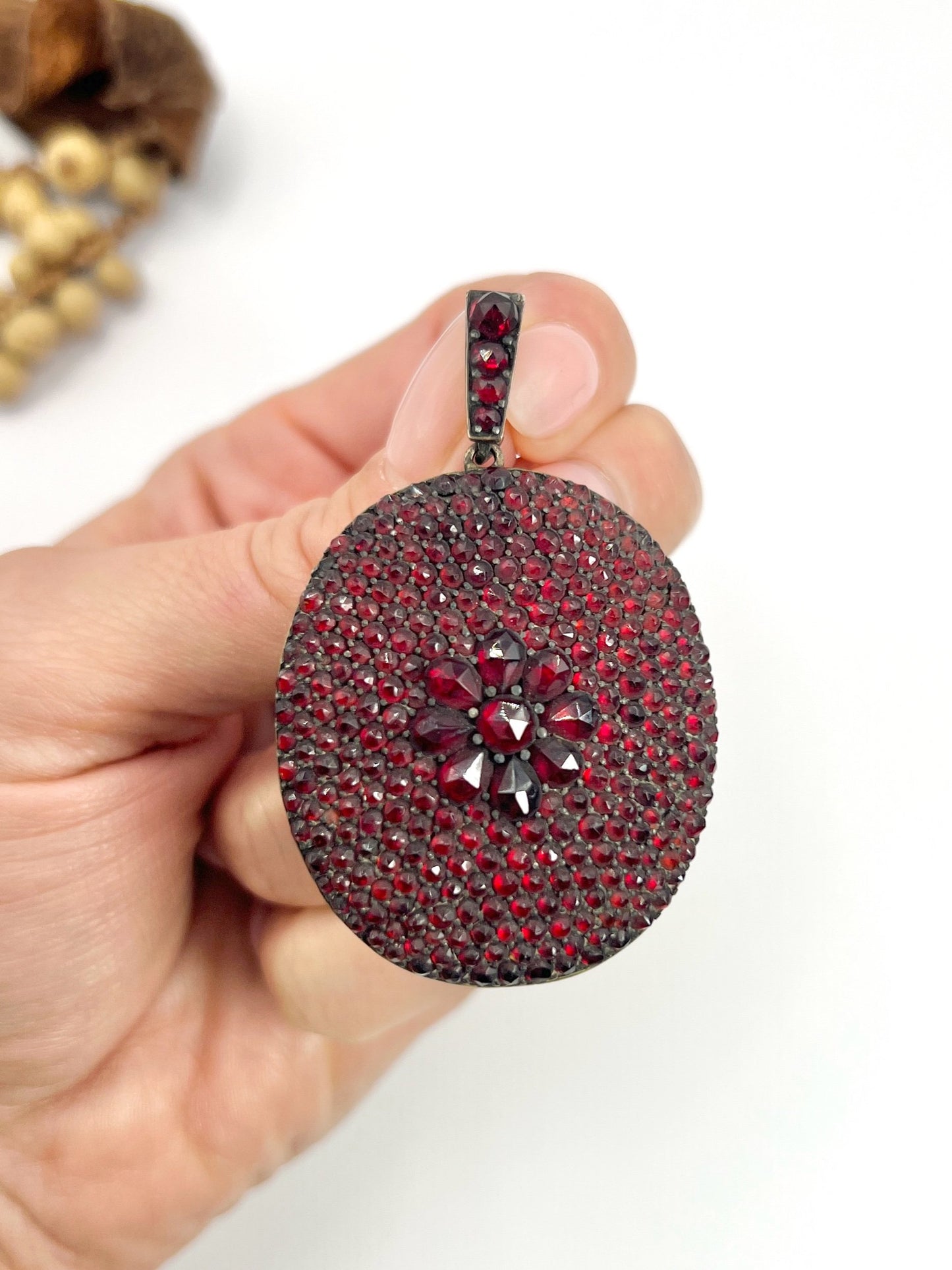 An antique oval locket encrusted with garnets
