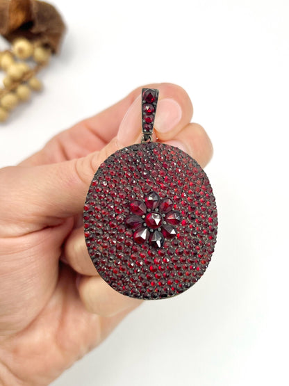 An antique oval locket encrusted with garnets