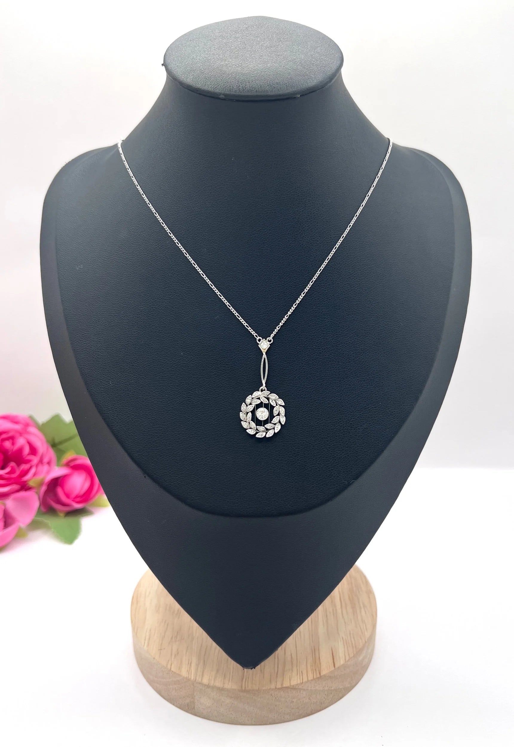 A platinum floral wreath pendant with diamonds on a platinum chain