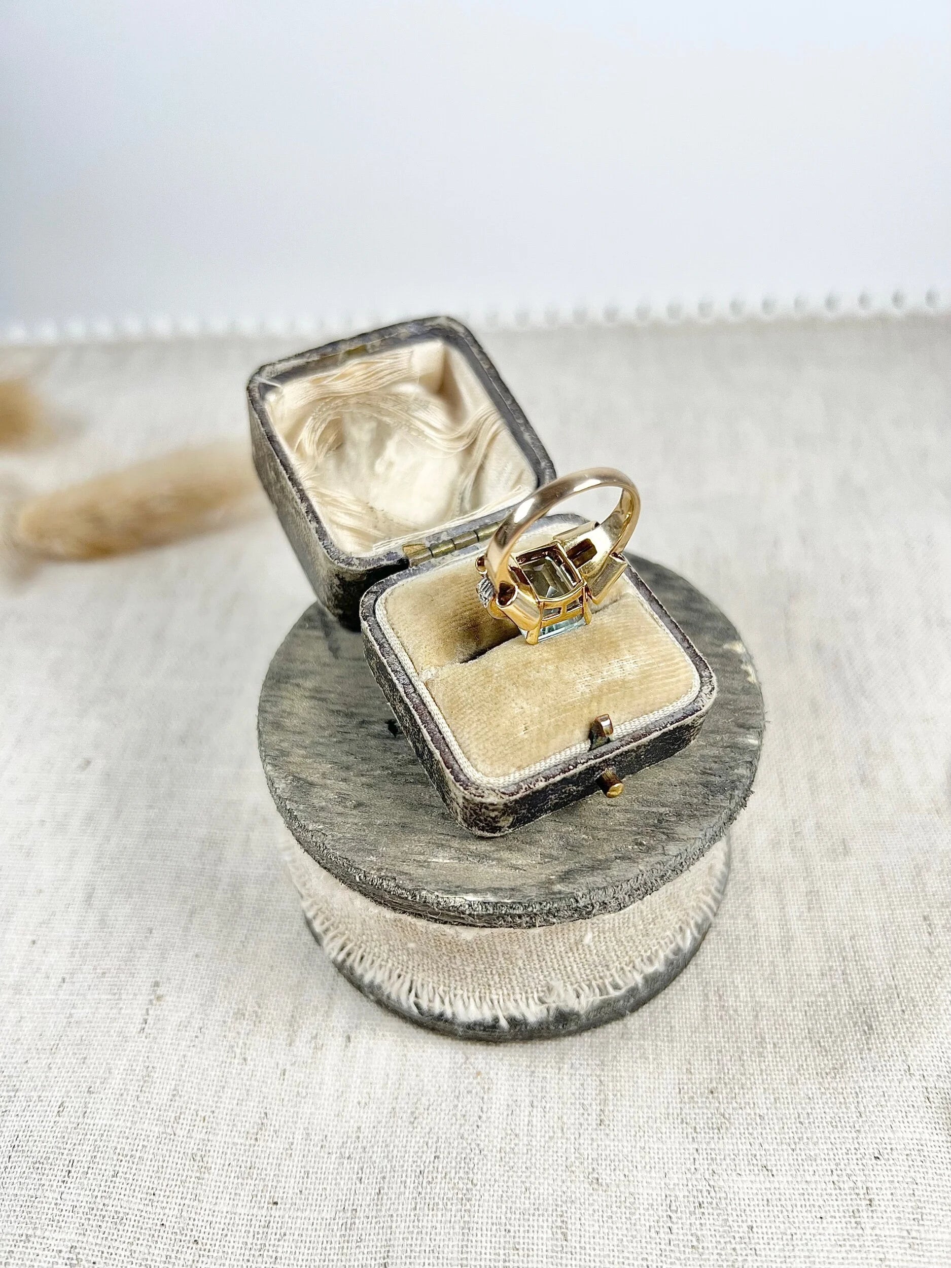 An aquamarine and diamond cocktail ring in gold, in an antique ring box