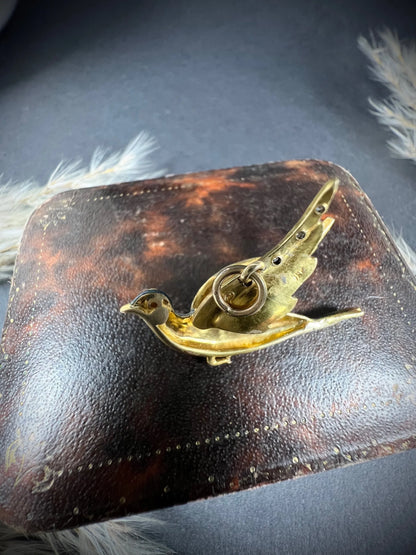An enamel and diamond dove bird pendant, on an antique box