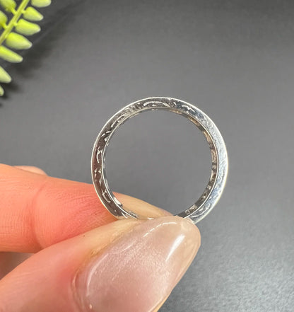 A diamond full eternity ring in white gold, held in a hand