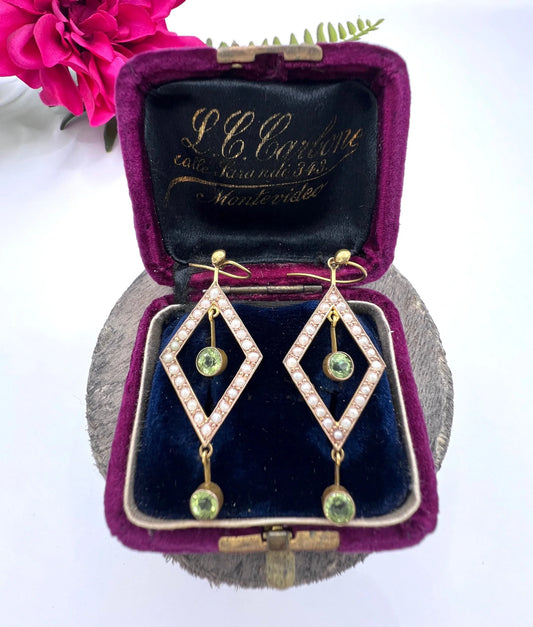 A pair of open diamond shaped drop earrings with peridots and pearls in yellow gold, in an antique box