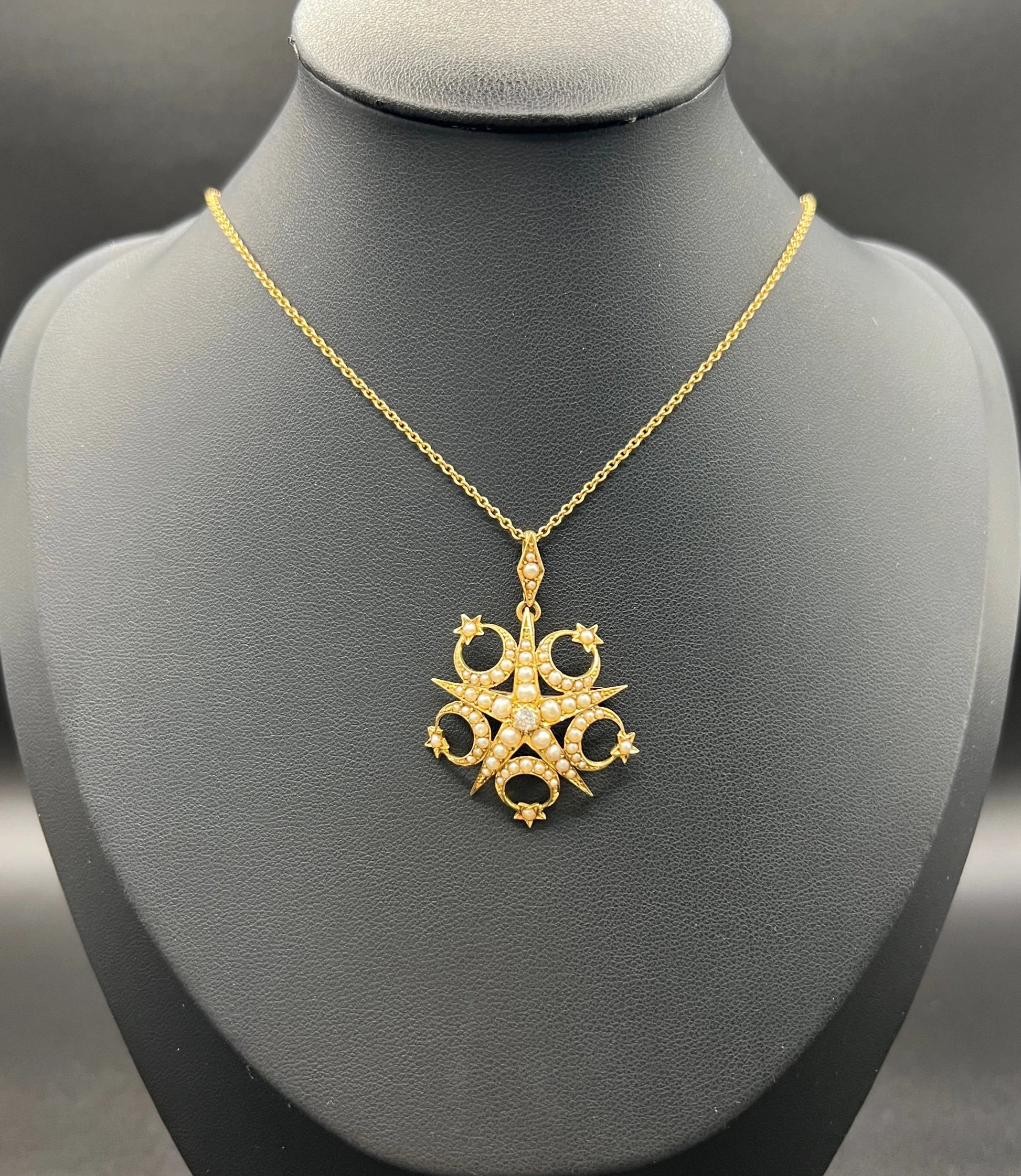 A yellow gold star and crescent brooch/pendant set with a diamond and pearls, with a gold chain