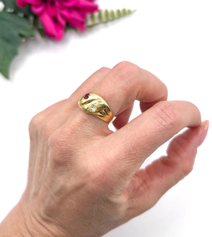 A yellow gold double headed snake ring with a ruby and a diamond, modelled on a hand