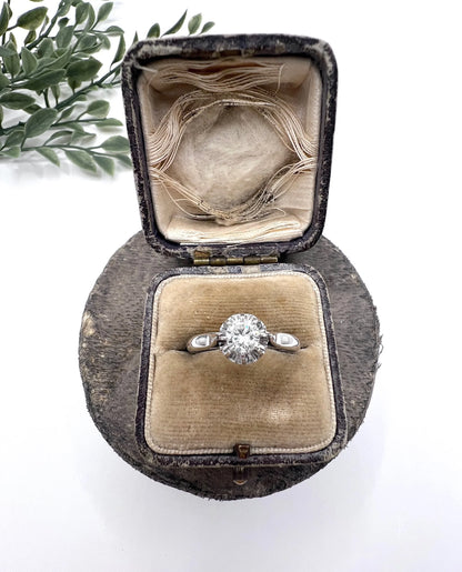 A solitaire round diamond ring in white gold, in an antique ring box
