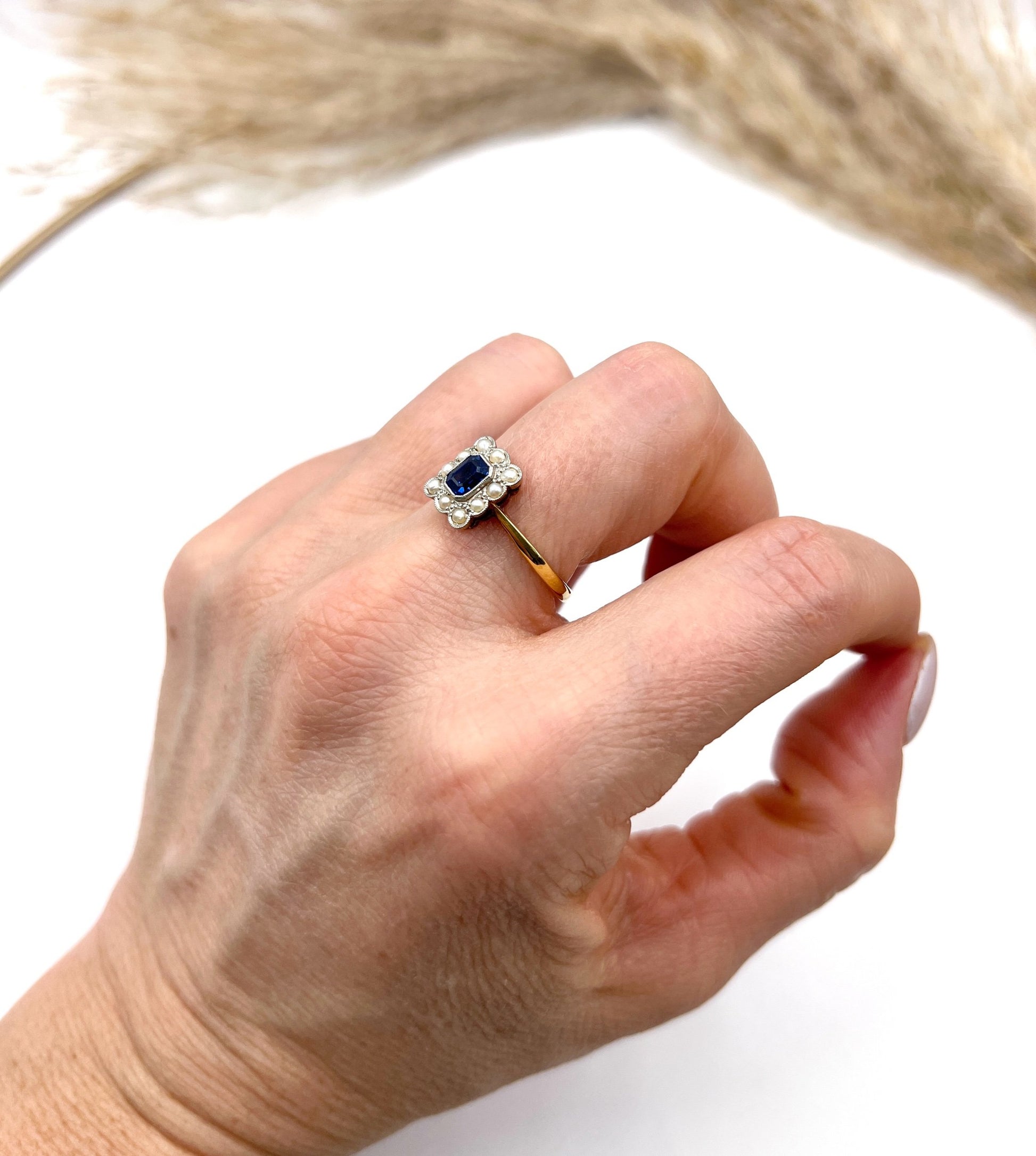 A sapphire and pearl cluster ring in yellow gold and platinum, modelled on a hand