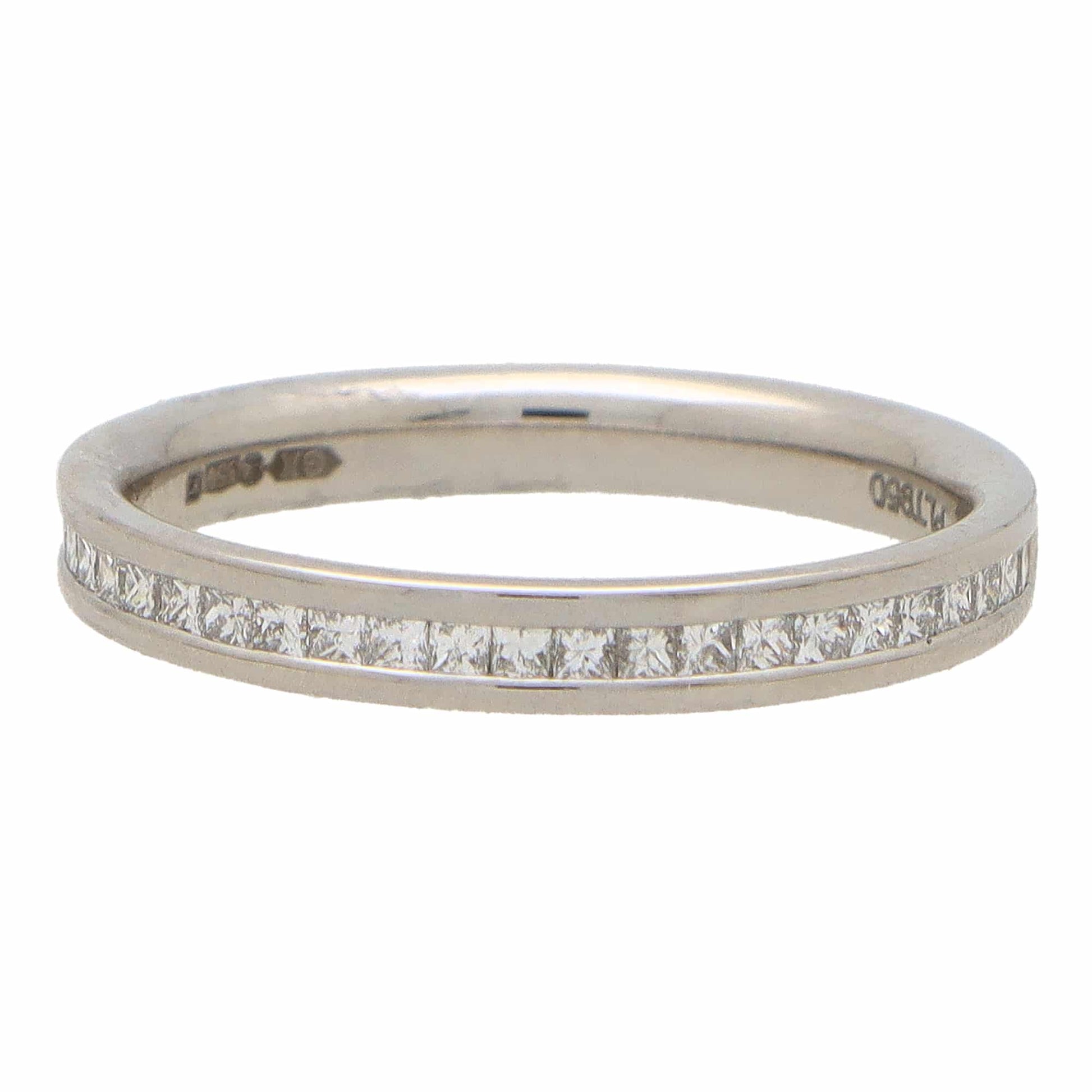 A platinum eternity ring with princess cut diamonds, on a white background