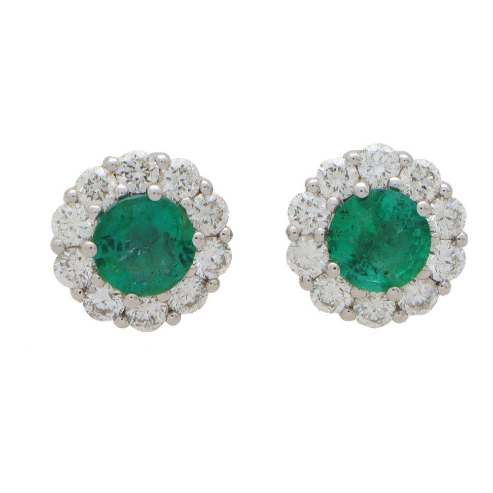 Emerald and diamond cluster earrings set in white gold.