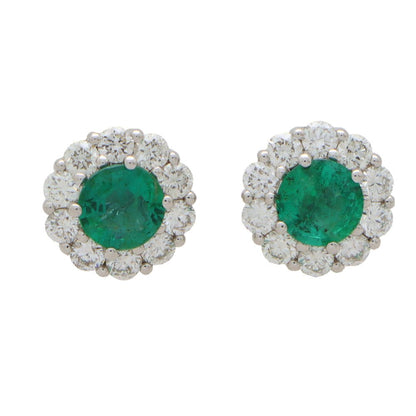 Emerald and diamond cluster earrings set in white gold.