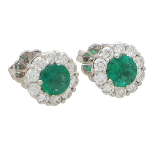 Emerald and diamond cluster earrings set in white gold.