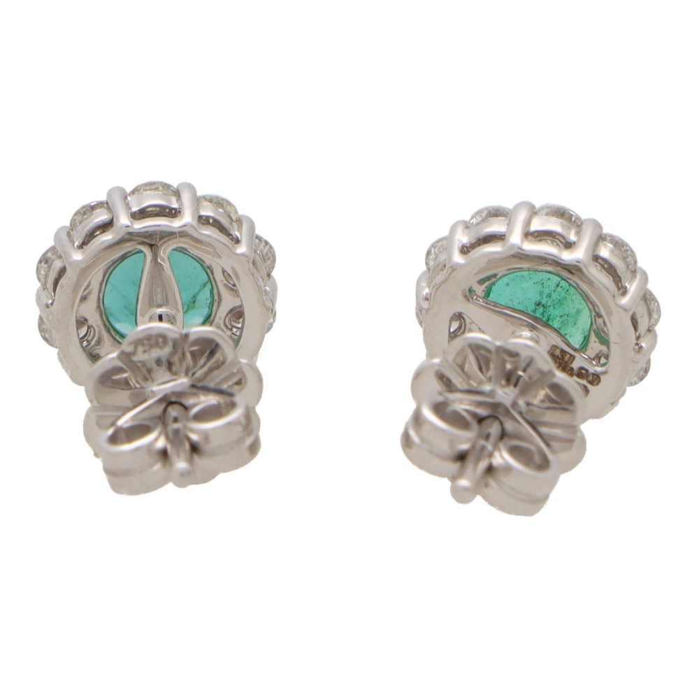 Emerald and diamond cluster earrings set in white gold.