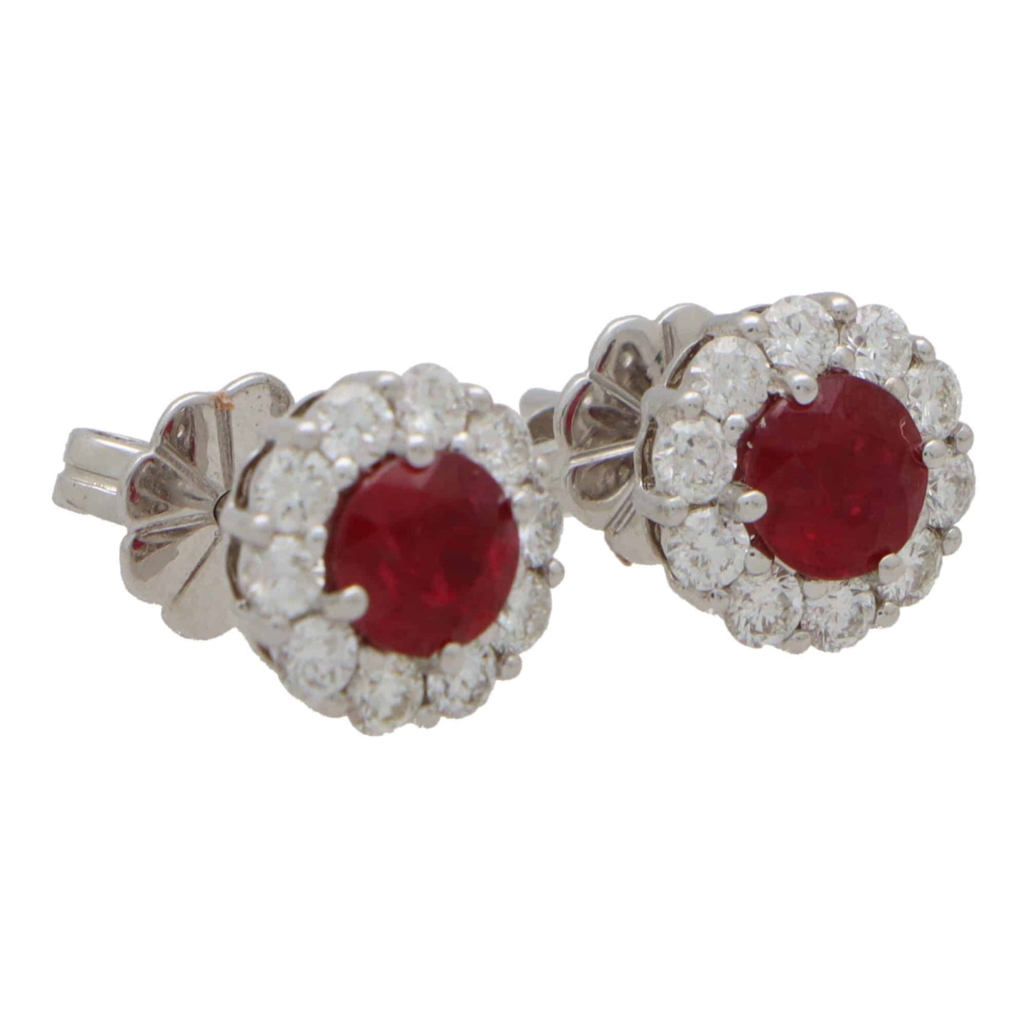 A pair of round ruby and diamond cluster earrings on a white background