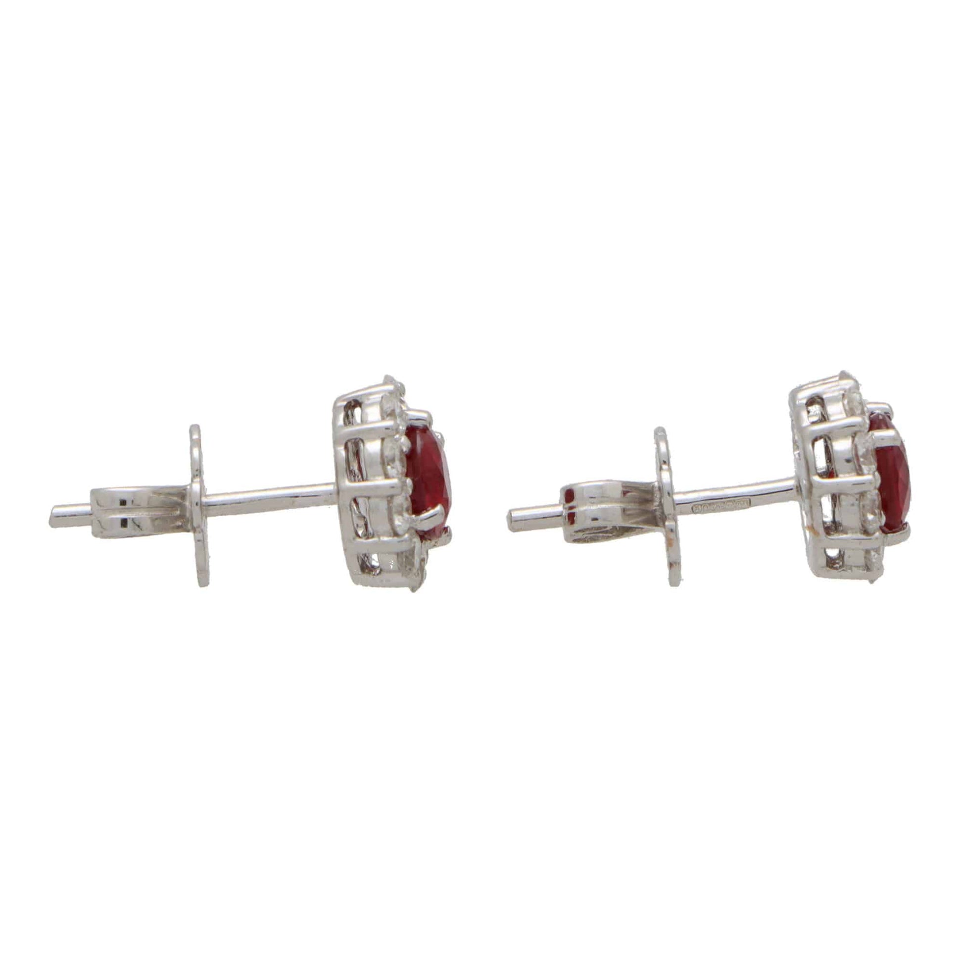 A pair of round ruby and diamond cluster earrings on a white background