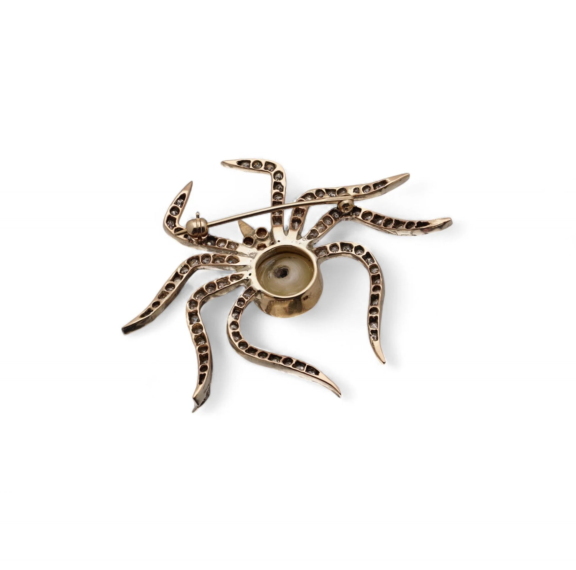 A spider brooch, in gold and silver, on a white background
