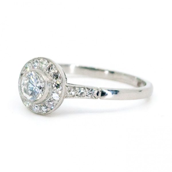 This lovely engagement vintage Art Deco revivalist design ring features a 0.40ct (H SI1) brilliant cut diamond decorated with 0.25ct single cut diamonds crafted in platinum.