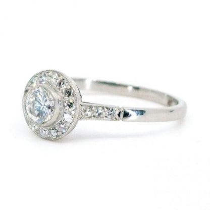 This lovely engagement vintage Art Deco revivalist design ring features a 0.40ct (H SI1) brilliant cut diamond decorated with 0.25ct single cut diamonds crafted in platinum.