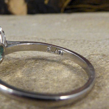 A beautiful contemporary ring featuring a 0.50ct emerald cut emerald with a diamond surround. With princess and modern brilliant cut diamonds alternating around the emerald, this ring has a total of 0.35ct diamonds allowing it to sparkle beautifully on the finger all set in platinum in a millegrain edge.