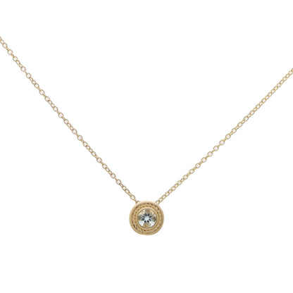 A yellow gold pendant necklace with a round aquamarine, on a white background