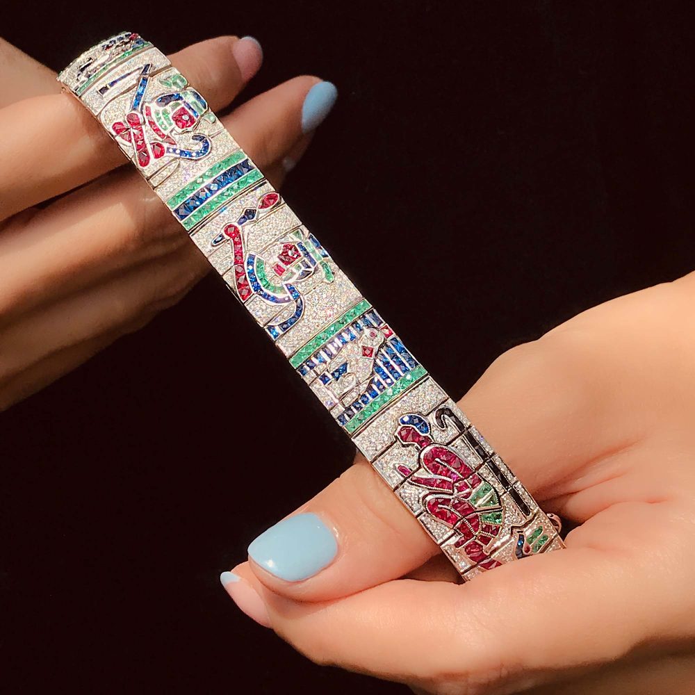 Diamond and Multi Gemstone Egyptian Revival Bracelet, with diamonds, blue sapphires, red rubies, green emeralds and black onyx in 18ct white gold