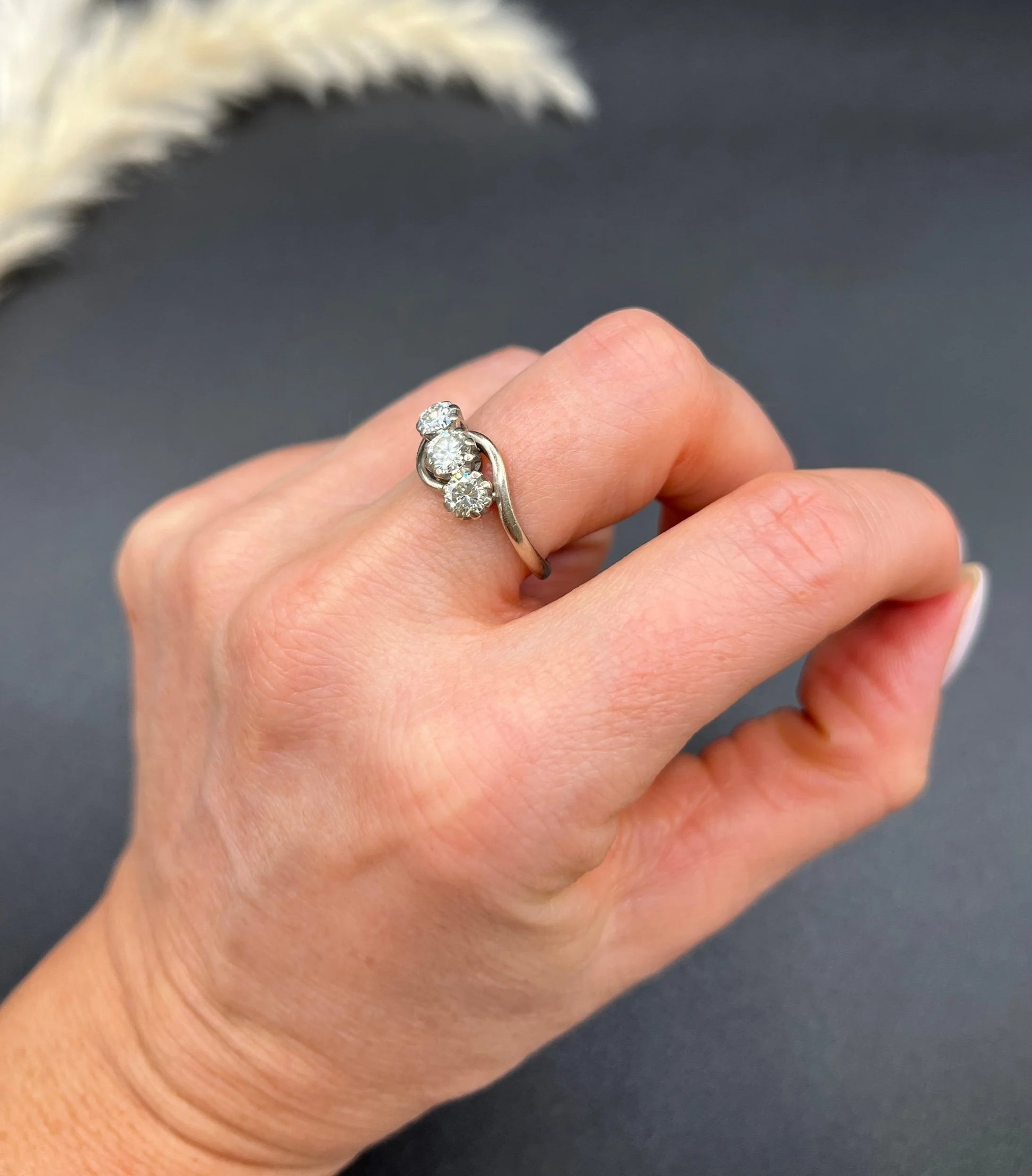 A three stone diamond crossover ring, modelled on a hand