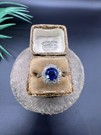 A circular cluster ring with sapphire and diamonds in yellow gold and platinum, in an antique ring box