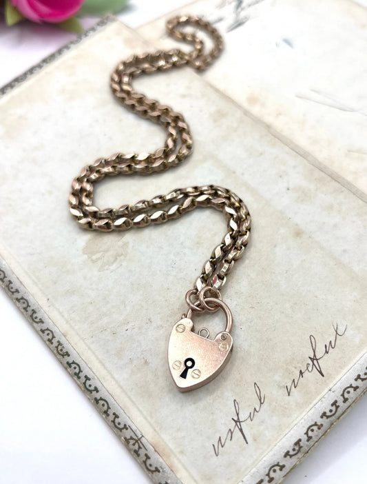 A rose gold heart padlock on a rose gold chain