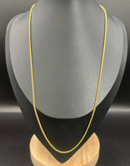 A yellow gold chain necklace, on a black jewellery bust