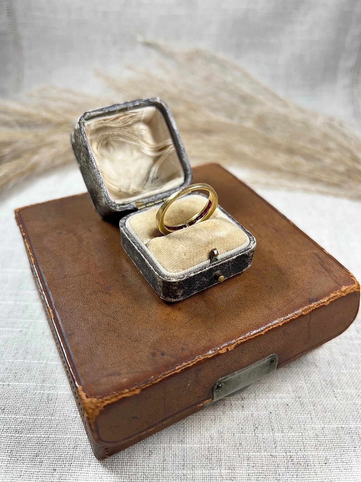 A yellow gold ruby channel set eternity band, in an antique ring box