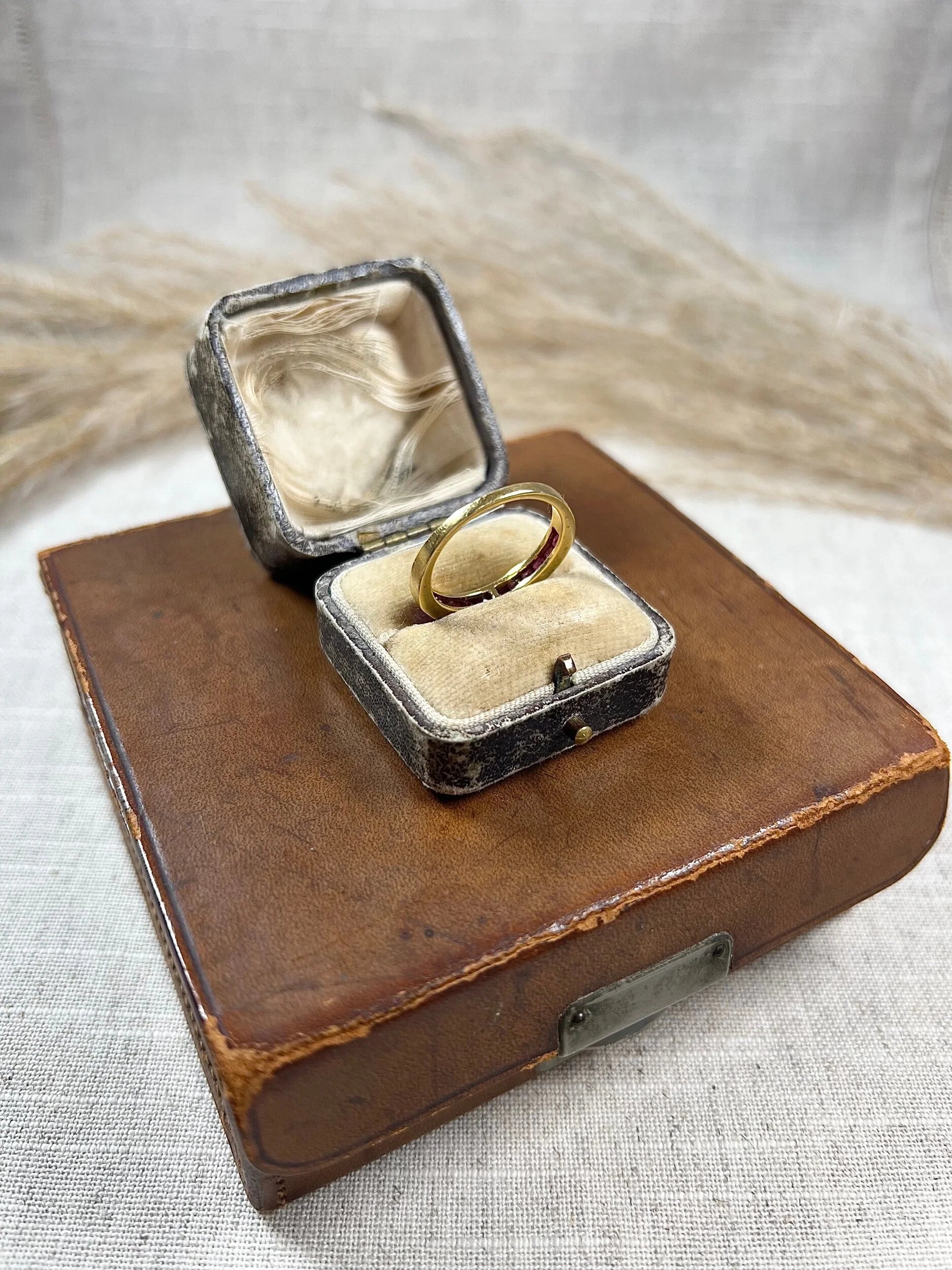 A yellow gold ruby channel set eternity band, in an antique ring box