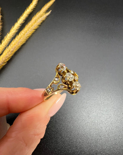 An antique old cut diamond ring in yellow gold, held in a hand
