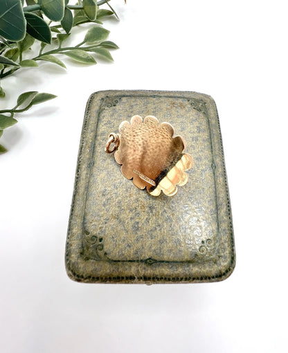 A cabochon garnet pendant with a seed pearl border in rose gold