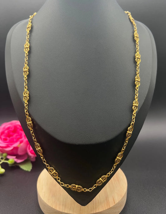 A yellow gold fancy link chain necklace, modelled on a black jewellery bust