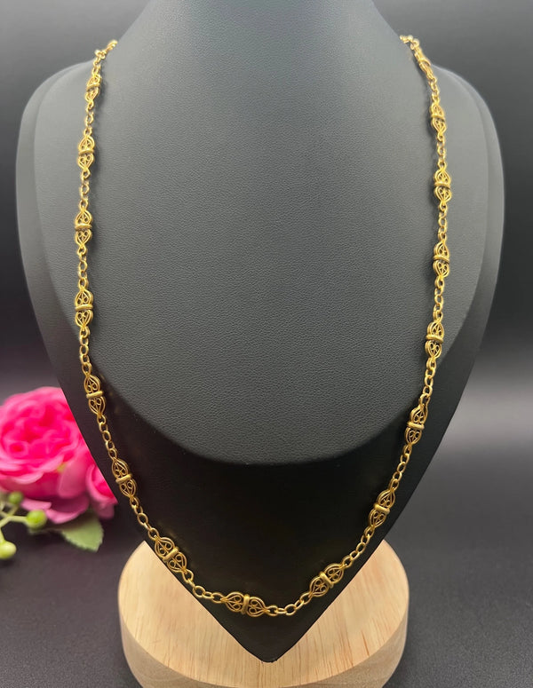 A yellow gold fancy link chain necklace, modelled on a black jewellery bust