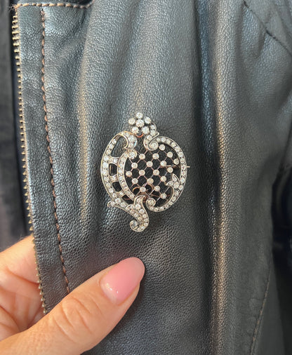 An openwork diamond set antique brooch in yellow gold and silver, modelled on a black leather jacket