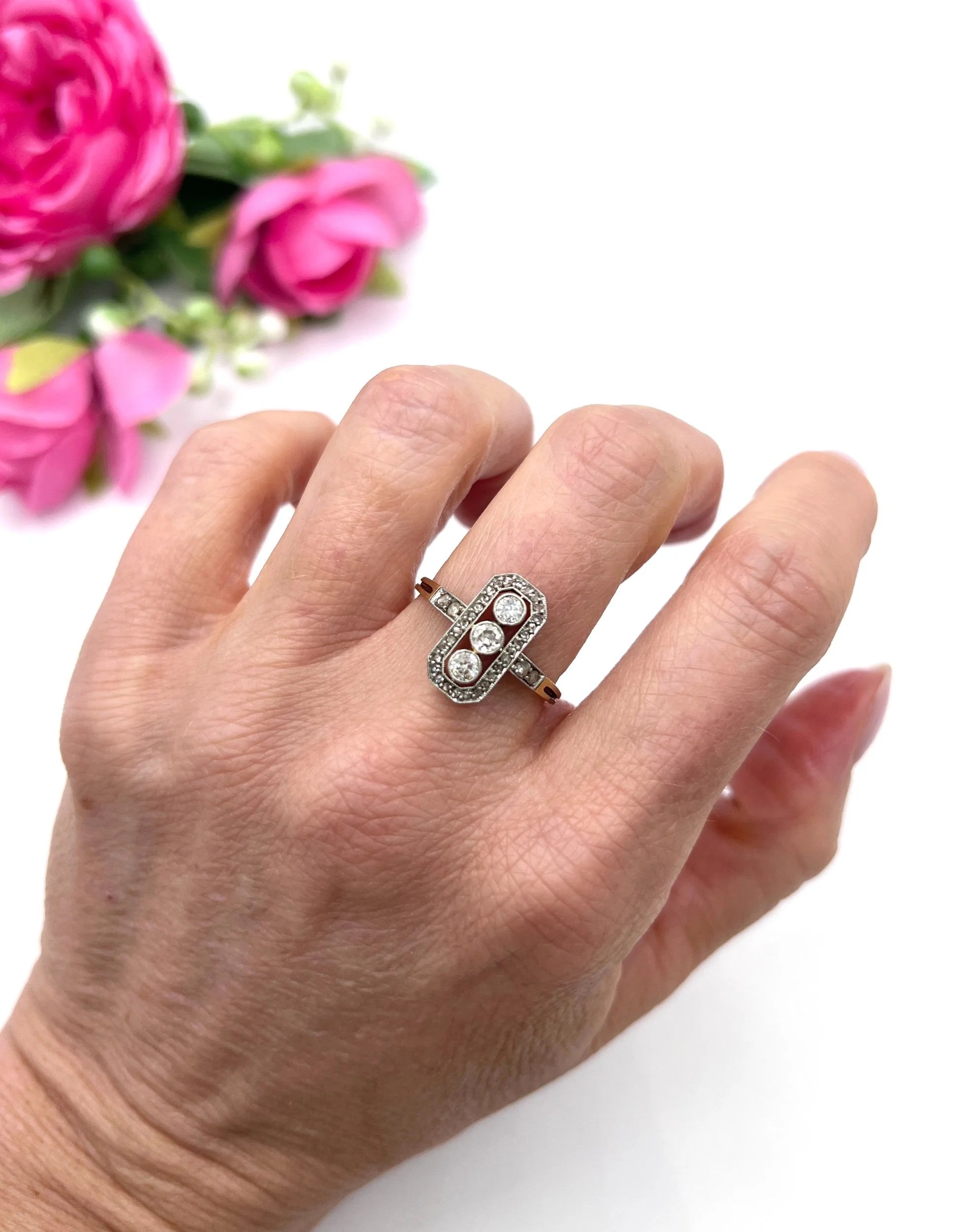 A diamond open cluster ring with three principal diamonds, in yellow and white gold, modelled on a hand