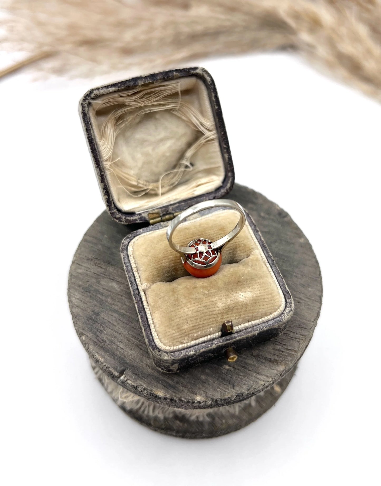 A round orange coral and diamond dress ring in platinum, in an antique ring box