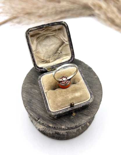 A round orange coral and diamond dress ring in platinum, in an antique ring box