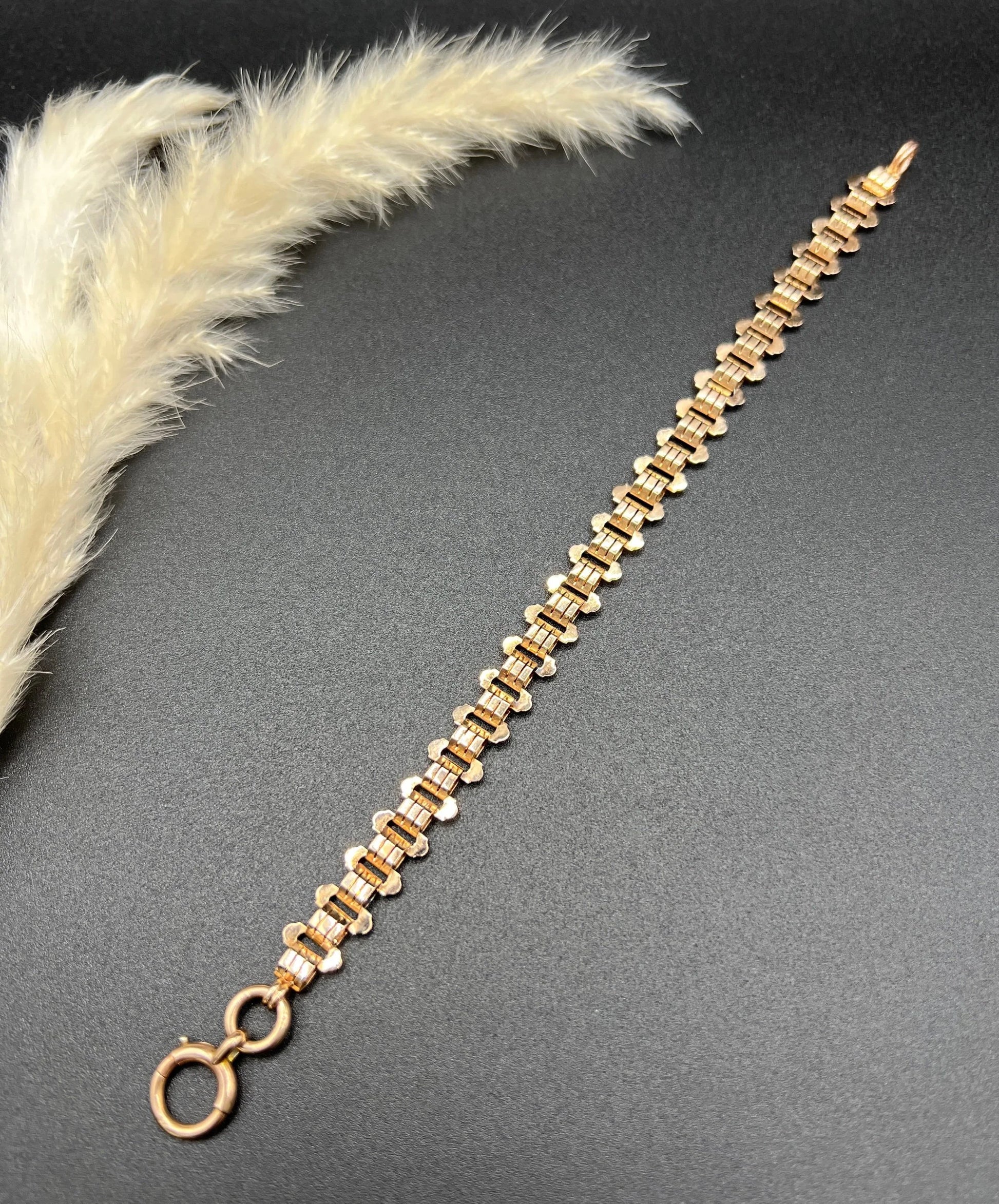 A rose gold fancy link bracelet with a bolt ring clasp