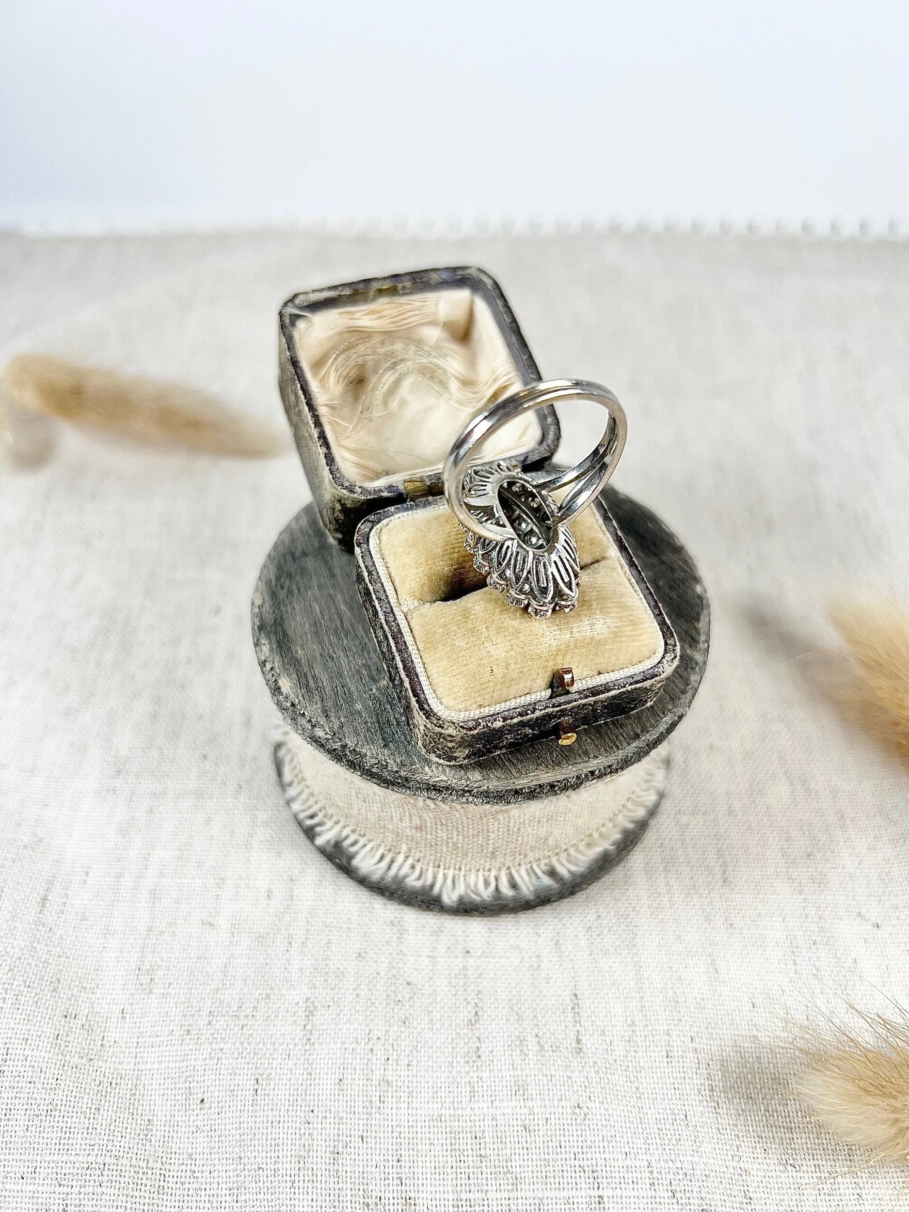 A navette shaped diamond cluster ring in white metal, in an antique ring box