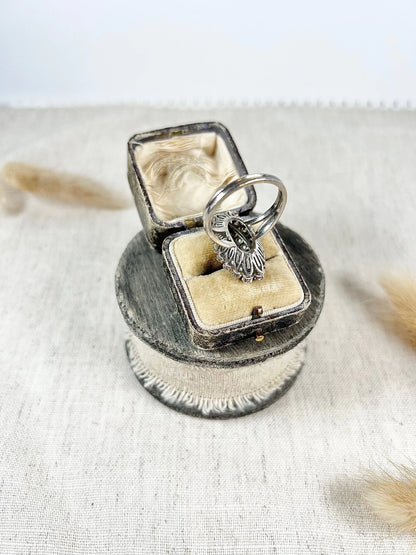 A navette shaped diamond cluster ring in white metal, in an antique ring box