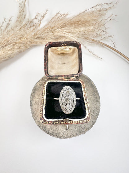 Antique 18 Carat White Gold Three Stone Diamond Oval Halo Ring, Circa 1910